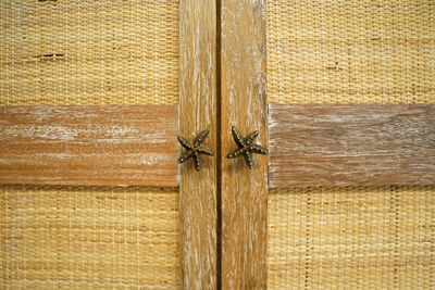 Close up wooden weave door with starfish shaped handles