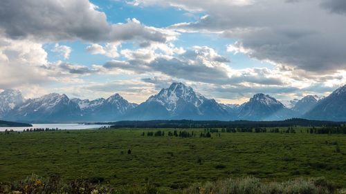 Scenic view of field and mountains against sky