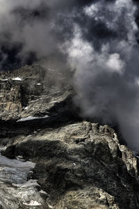 Smoke emitting from mountain against sky