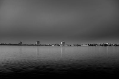Scenic view of river against sky in city