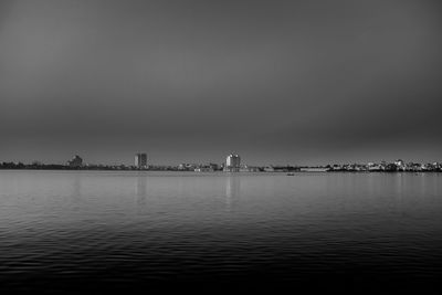 Scenic view of river against sky in city