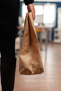 Midsection of woman holding paper bag