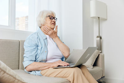 Senior woman using laptop at home