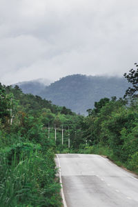 Road amidst trees against sky during rainy season