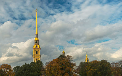 Low angle view of trees and building against sky