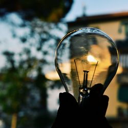 Close-up of hand holding light bulb
