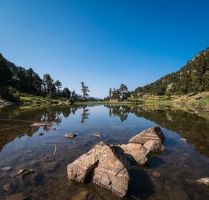 Scenic view of lake against clear blue sky