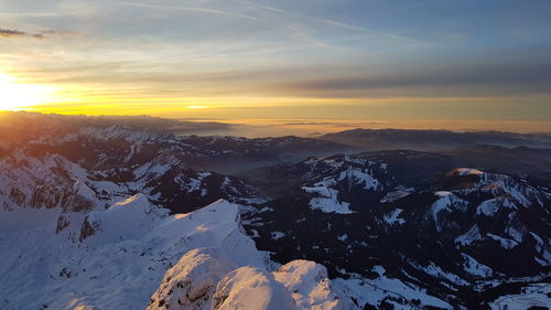 Scenic view of snowcapped mountains against sky during sunset