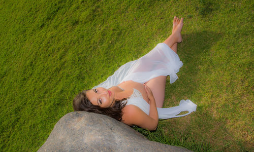 High angle view of woman lying down on grassy field