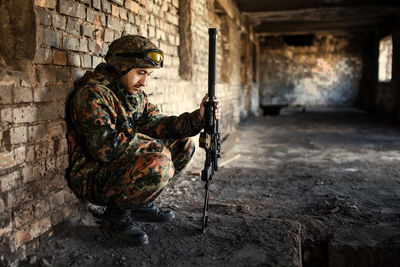 A thoughtful soldier, resting from a military operation location of ruins