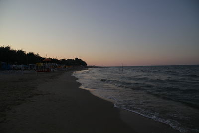 Scenic view of beach against clear sky during sunset