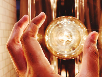 Midsection of person holding illuminated lamp