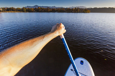 Hand by boat in lake