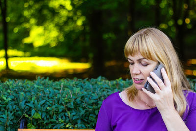 Mid adult woman using mobile phone outdoors
