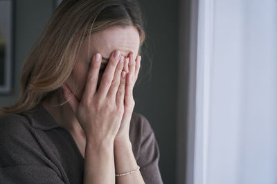 Depressed woman covering face with hands