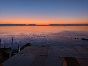 Scenic view of lake against clear sky during sunset