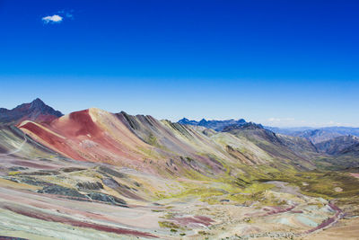 Scenic view of mountains against blue sky