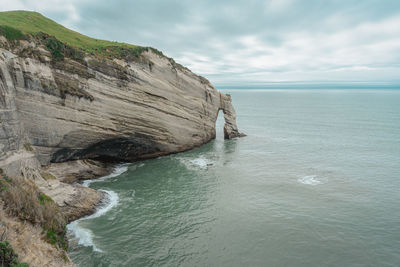 Rock formation in sea against sky