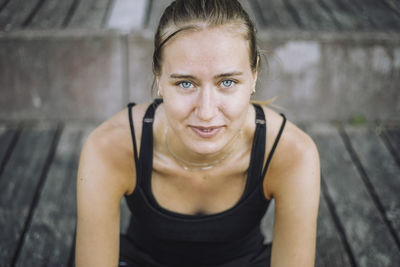 Portrait of smiling young woman with gray eyes sitting on steps