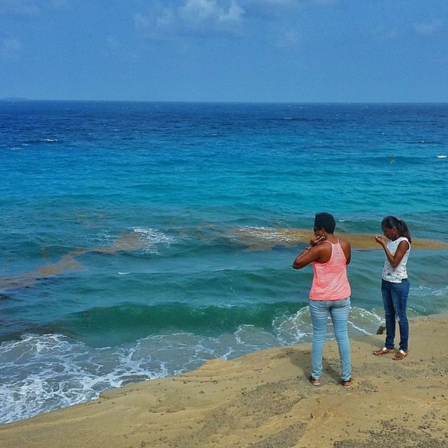 sea, water, horizon over water, lifestyles, leisure activity, full length, beach, childhood, casual clothing, shore, rear view, boys, girls, elementary age, standing, vacations, sky, beauty in nature