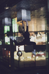 Upside down image of woman doing handstand on street at night