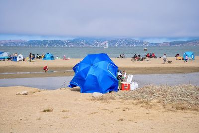 People on beach against sky