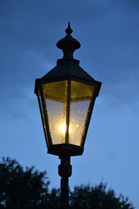 Low angle view of illuminated street light against sky