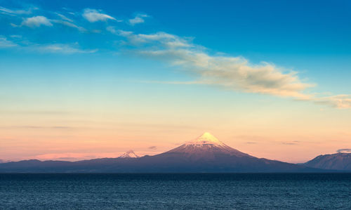 Scenic view of sea against cloudy sky during sunset