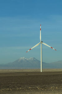 Windmill on field against sky