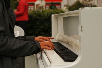 Midsection of man playing piano