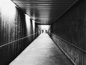 Rear view of woman walking in tunnel