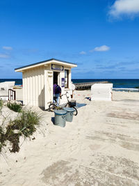 Lifeguard hut on beach against blue sky