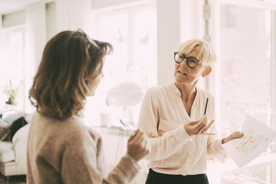 Two businesswomen having a conversation at home