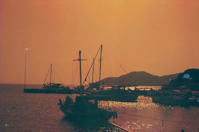 Boats in sea against sky during sunset