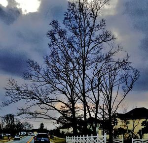 Cars on road against cloudy sky