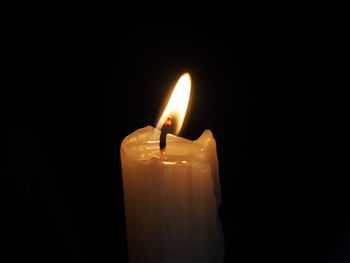 Close-up of illuminated candle against black background