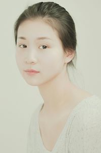 Close-up portrait of young woman over white background