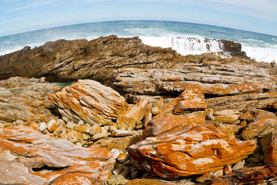 Rock formation on beach against sky