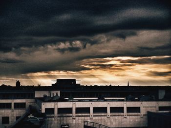 Buildings against cloudy sky at sunset