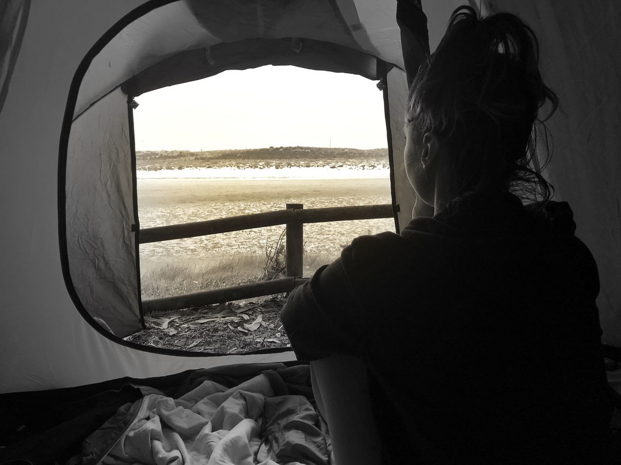 REAR VIEW OF WOMAN LOOKING THROUGH WINDOW AT SEA