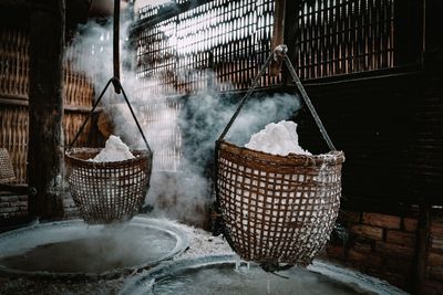 Rice in wicker baskets above water filled container with steam