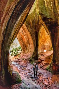 High angle view of young woman standing on rocks in cave