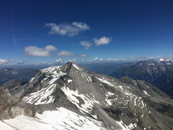 Scenic view of snowcapped mountains against blue sky