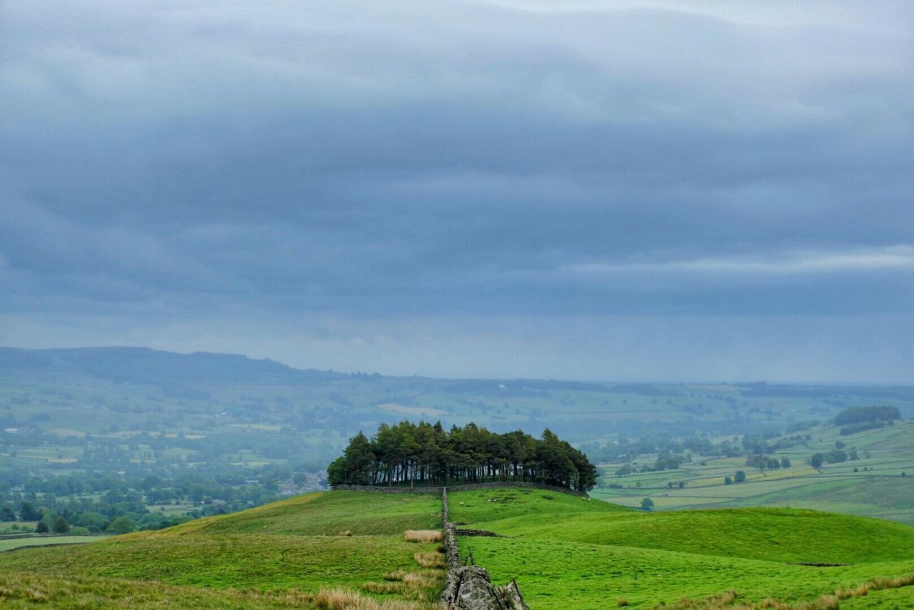 landscape, mountain, grass, sky, tranquil scene, field, scenics, tranquility, beauty in nature, green color, nature, mountain range, building exterior, grassy, cloud - sky, rural scene, built structure, tree, architecture, non-urban scene