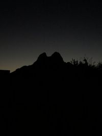 Silhouette mountains against clear sky at sunset