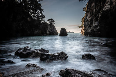 Scenic view of rocks in sea against sky