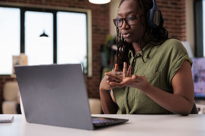 Young woman using laptop at table