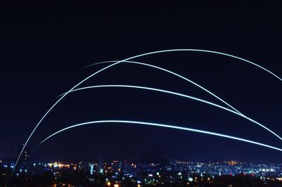 Low angle view of illuminated city against sky at night