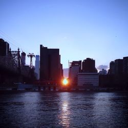 Buildings against clear sky at sunset