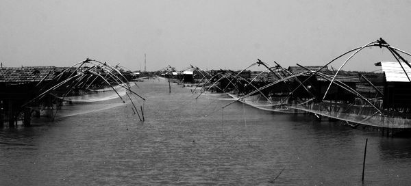 Fishing boats in sea against clear sky